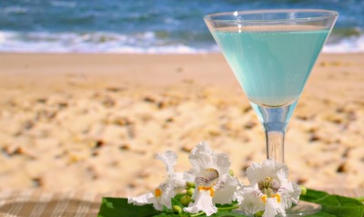 Голубой коктейль на берегу с цветками